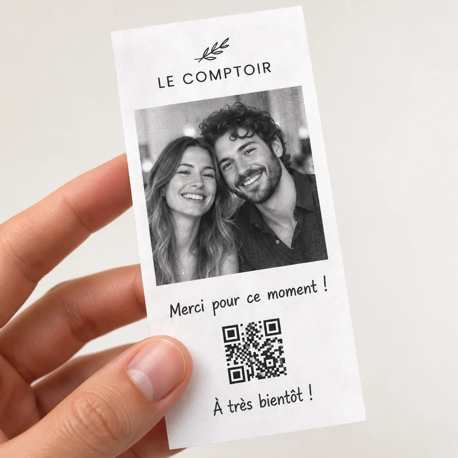 Des mains tiennent une photo souvenir imprimée sur un ticket